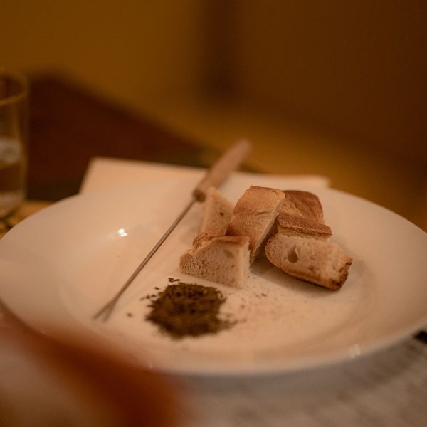 Fondue-Teller mit Brot und einem Glas Weisswein